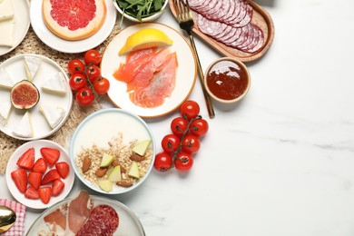 Photo of Different tasty food served for brunch on white marble table, flat lay. Space for text