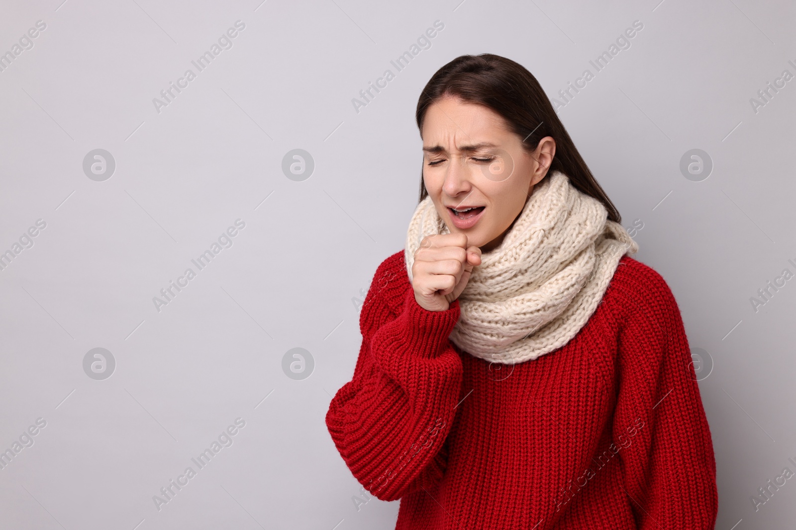 Photo of Sick woman coughing on grey background, space for text. Cold symptoms