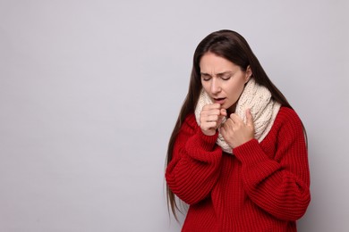 Photo of Sick woman coughing on grey background, space for text. Cold symptoms