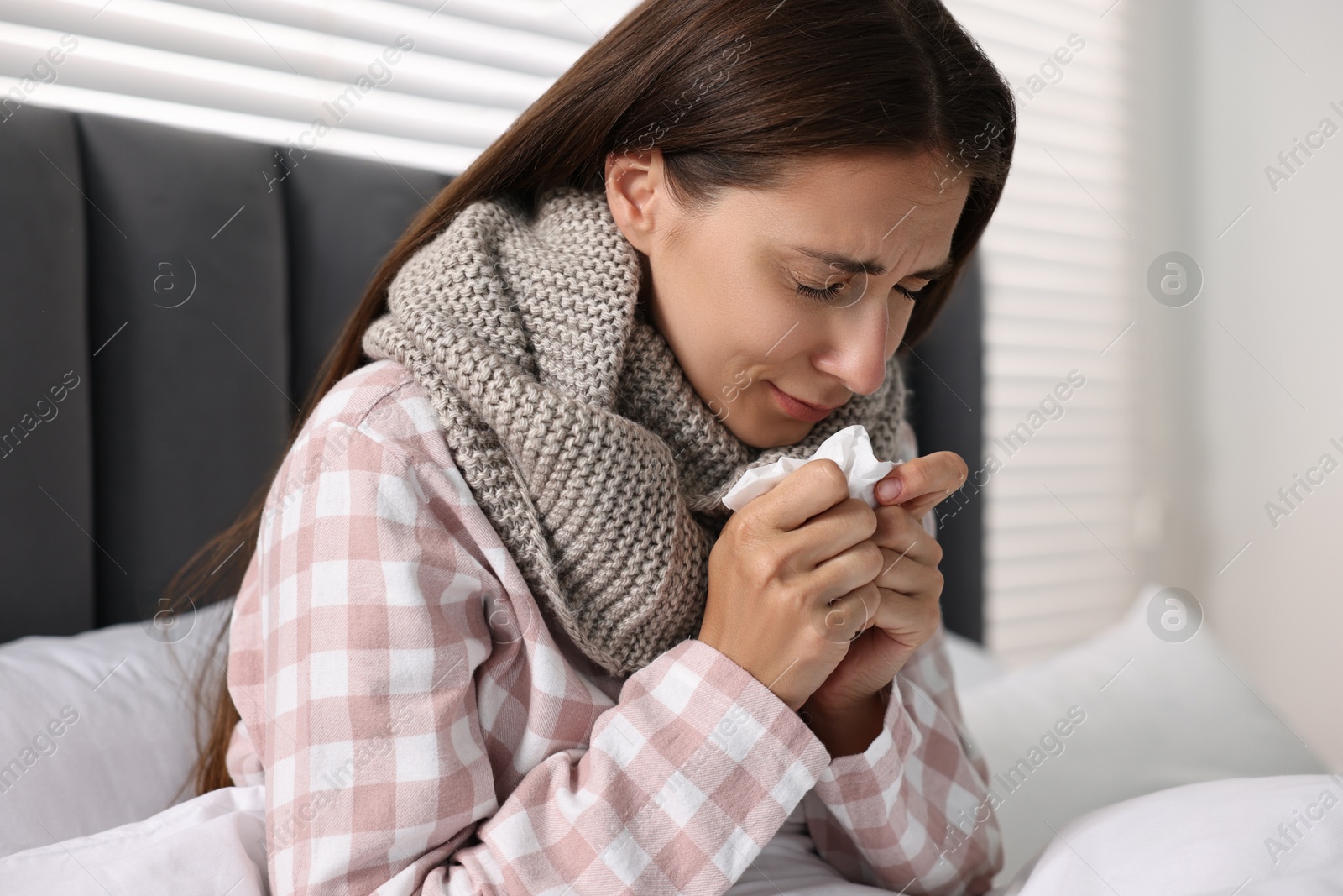 Photo of Sick woman with tissue in bed. Cold symptoms