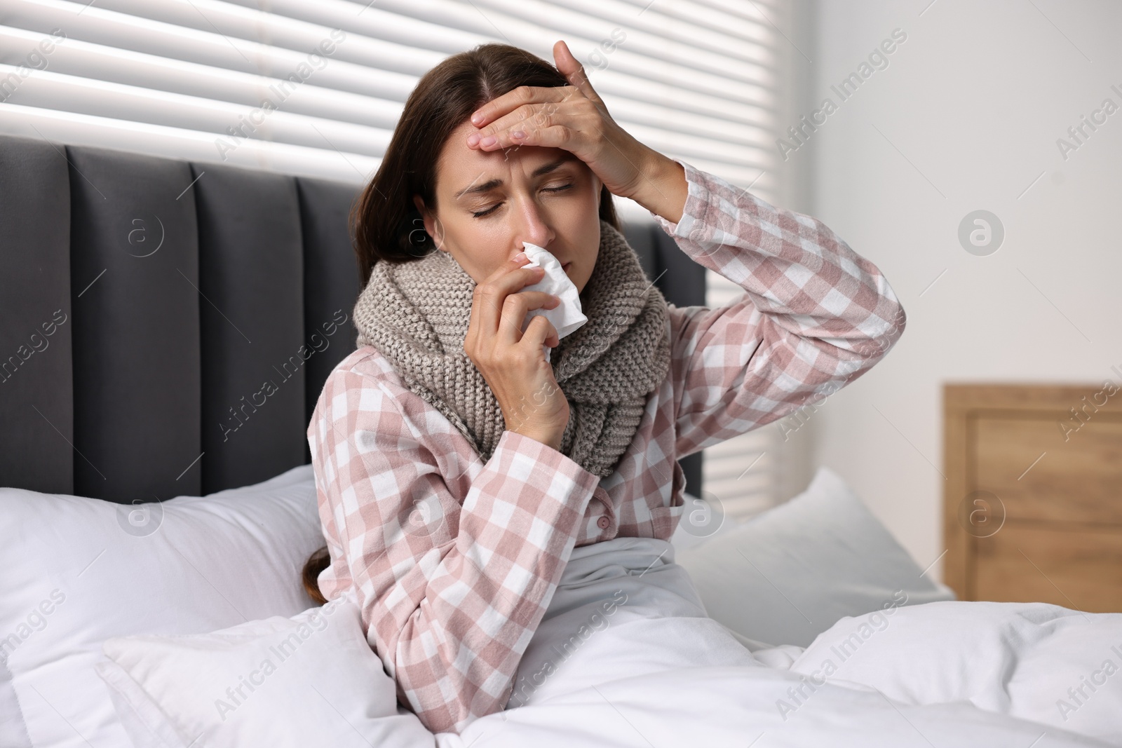 Photo of Sick woman with tissue in bed. Cold symptoms