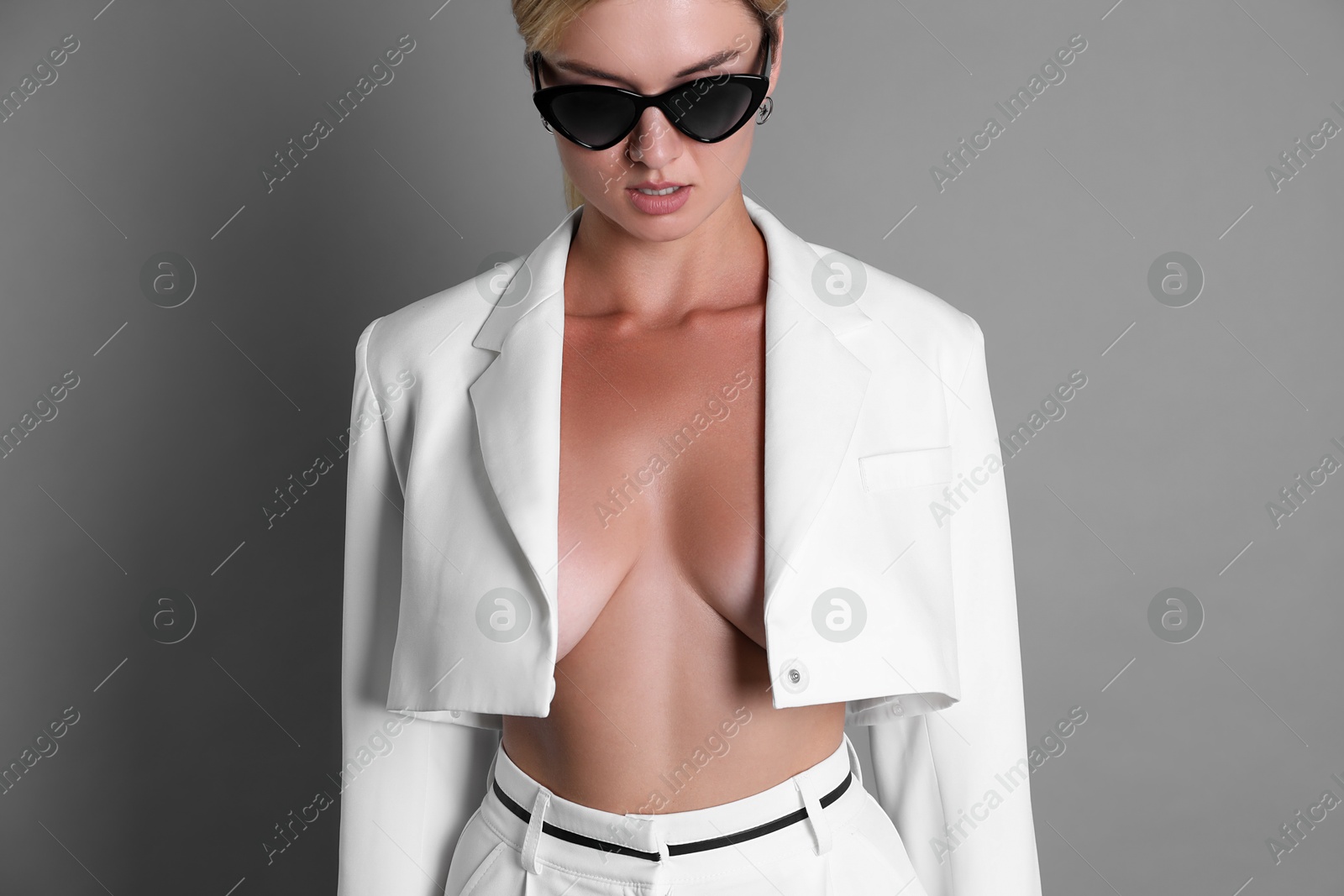 Photo of Beautiful woman in stylish white suit on grey background