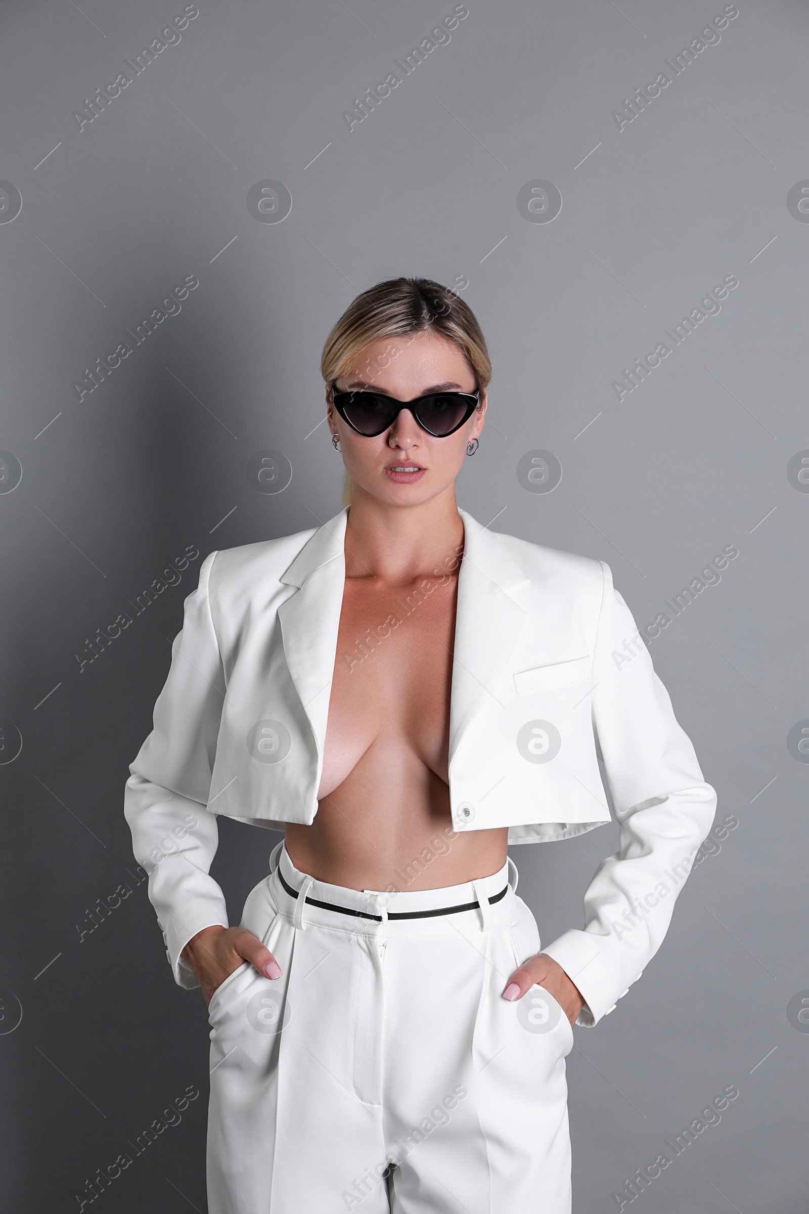 Photo of Beautiful woman in stylish white suit on grey background