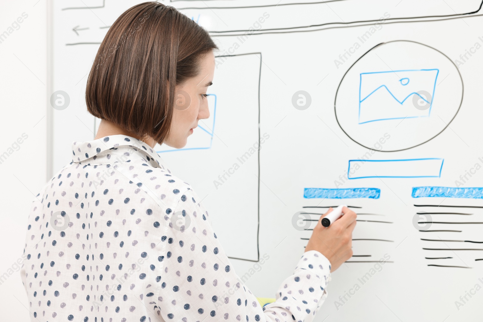 Photo of Developing UI design. Woman drawing website wireframe on whiteboard indoors