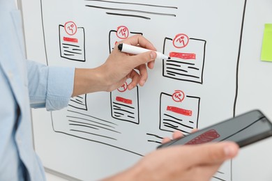 Developing UI design. Man drawing website wireframe on whiteboard indoors, closeup