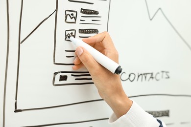 Photo of Developing UI design. Woman drawing website wireframe on whiteboard indoors, closeup