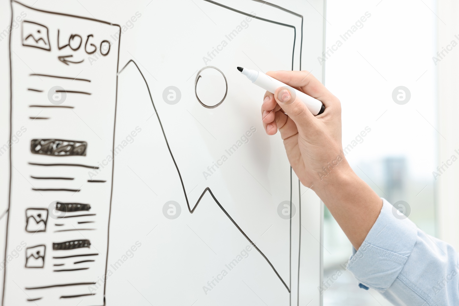 Photo of Developing UI design. Man drawing website wireframe on whiteboard indoors, closeup