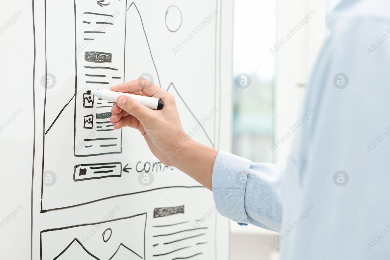 Photo of Developing UI design. Man drawing website wireframe on whiteboard indoors, closeup