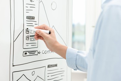 Photo of Developing UI design. Man drawing website wireframe on whiteboard indoors, closeup