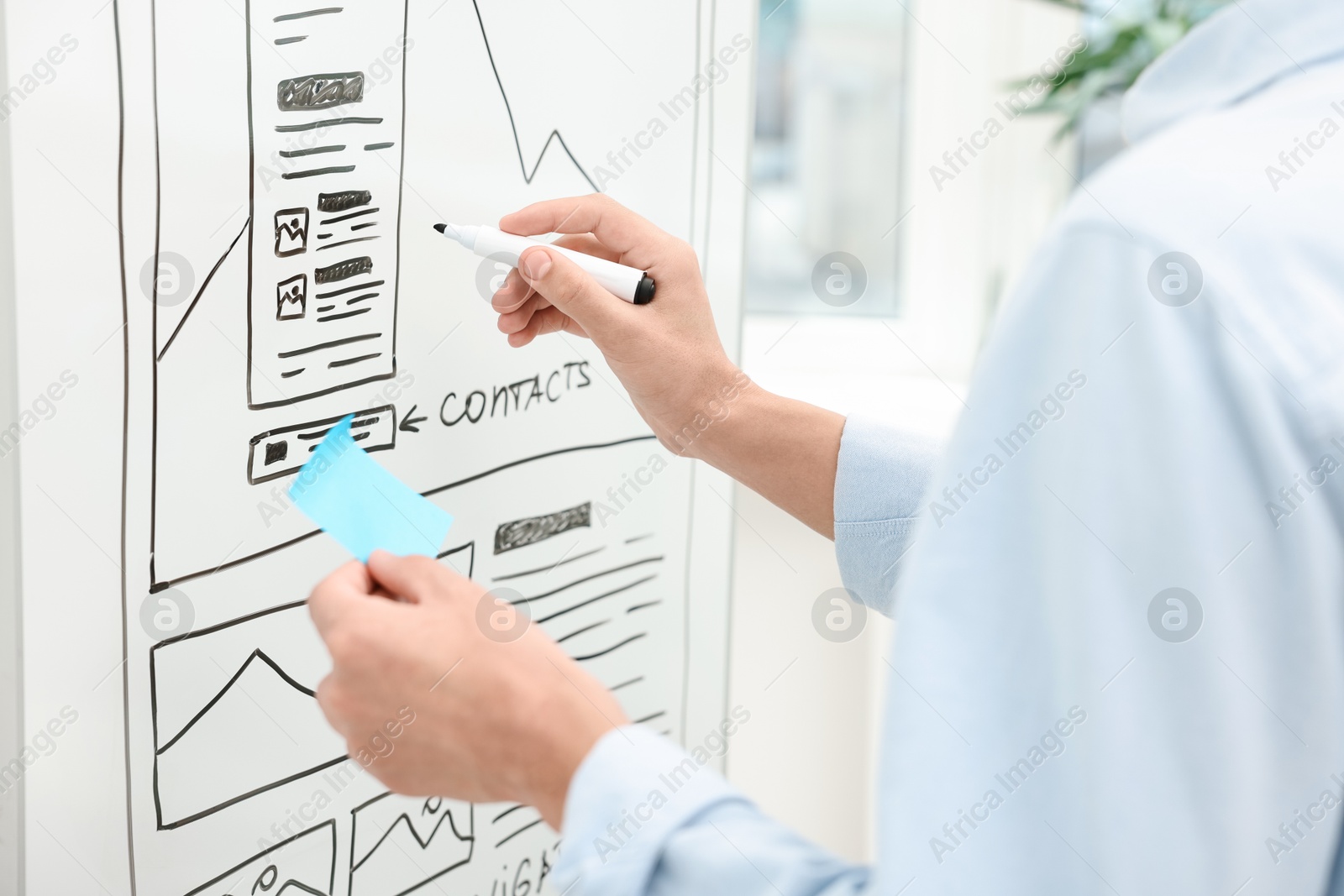 Photo of Developing UI design. Man drawing website wireframe on whiteboard indoors, closeup