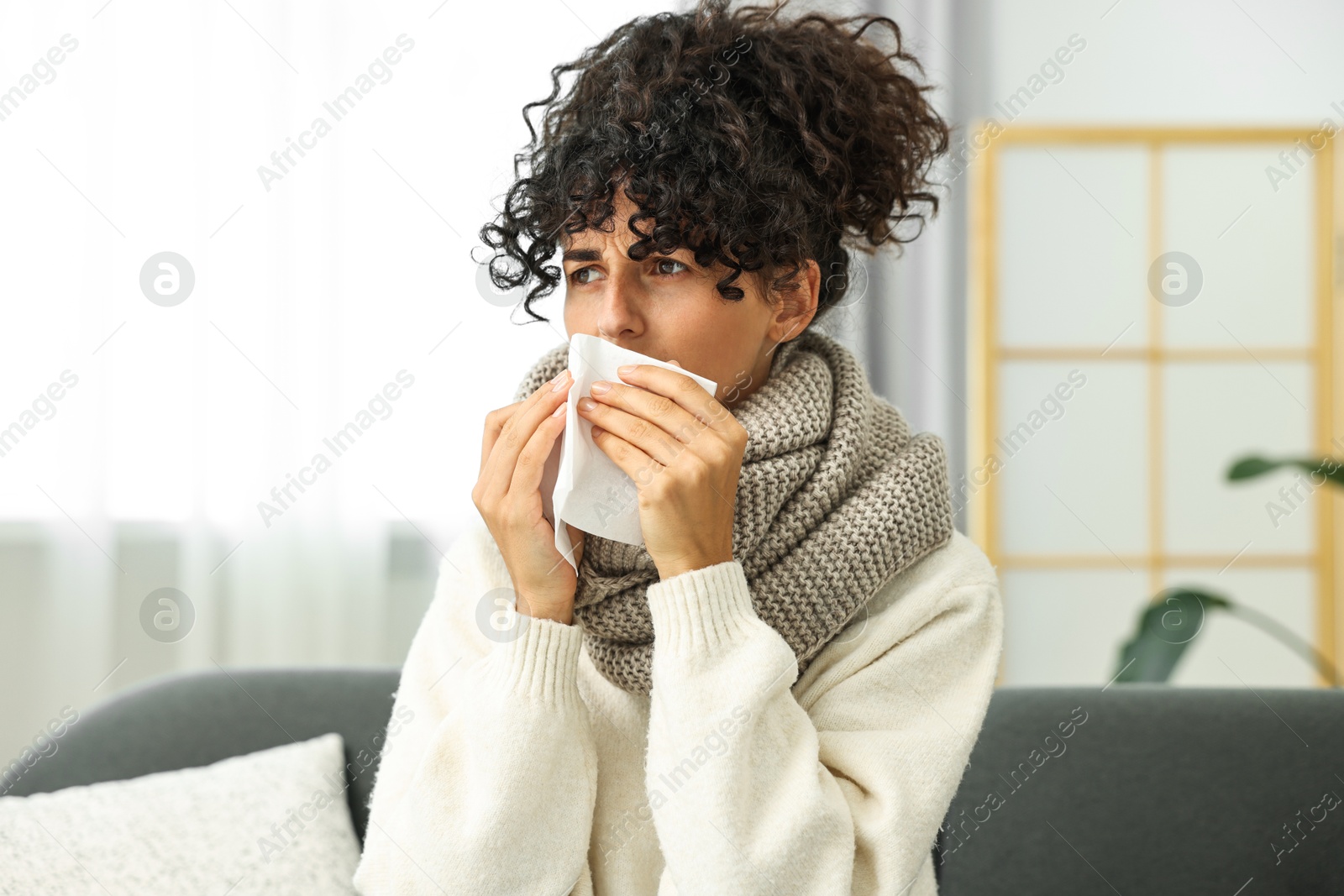 Photo of Cold symptom. Young woman with tissue at home