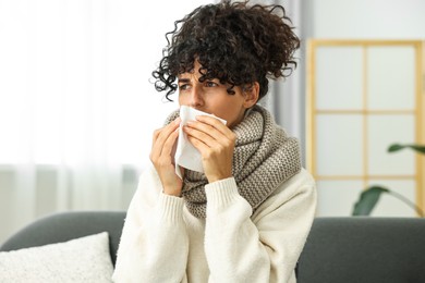 Cold symptom. Young woman with tissue at home