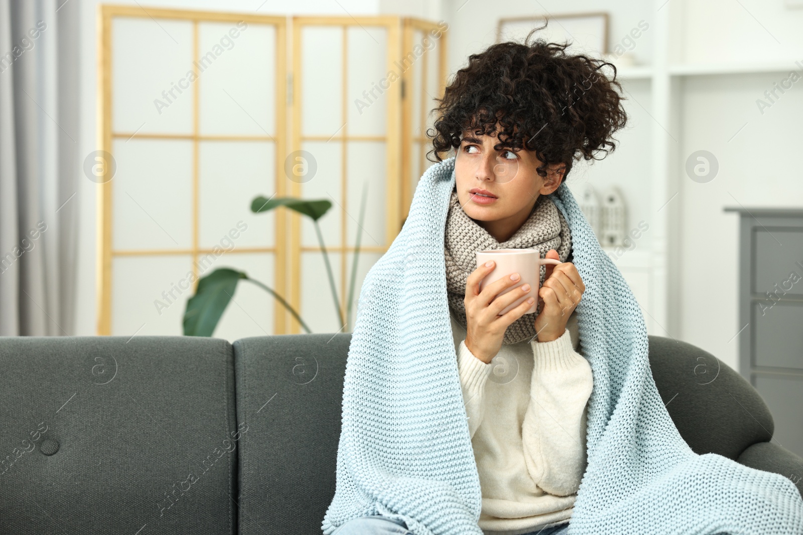 Photo of Cold symptom. Young woman with cup of hot drink at home