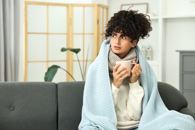 Photo of Cold symptom. Young woman with cup of hot drink at home