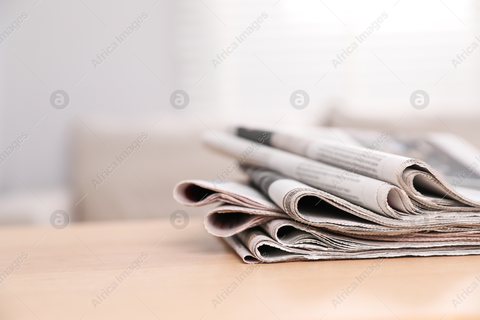 Photo of Stack of newspapers in different languages on table indoors. Space for text