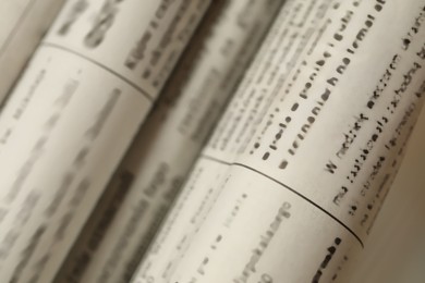 Photo of Many newspapers in different languages as background, closeup