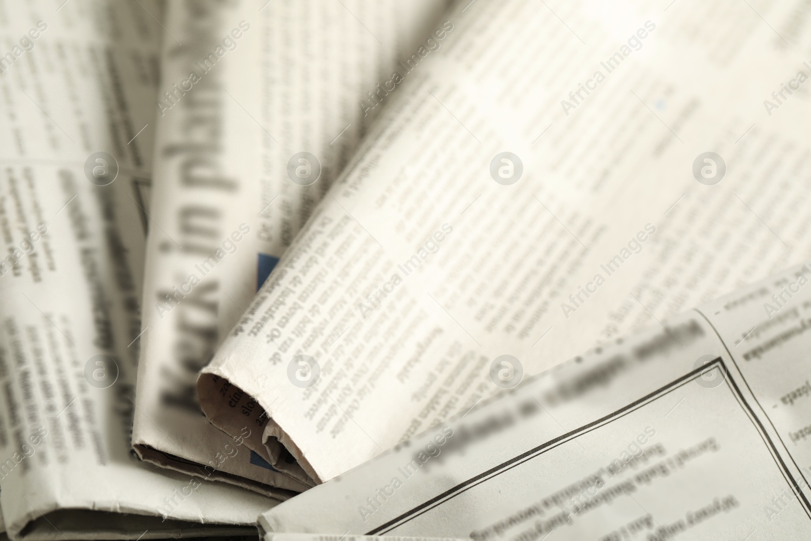 Photo of Many newspapers in different languages as background, closeup