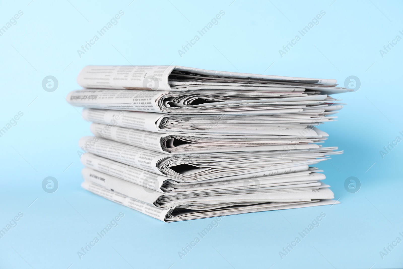 Photo of Stack of newspapers on light blue background