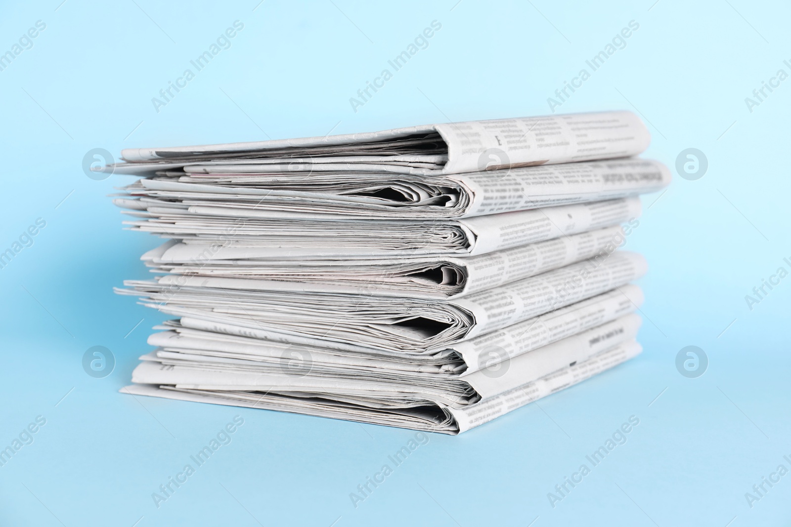 Photo of Stack of newspapers on light blue background