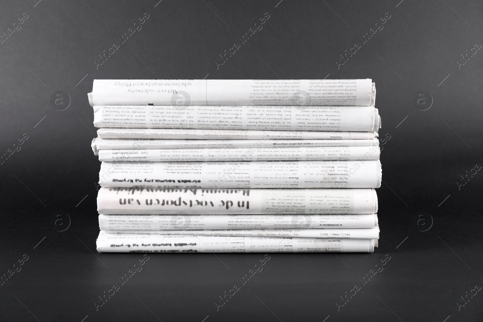 Photo of Stack of many newspapers in different languages on grey background