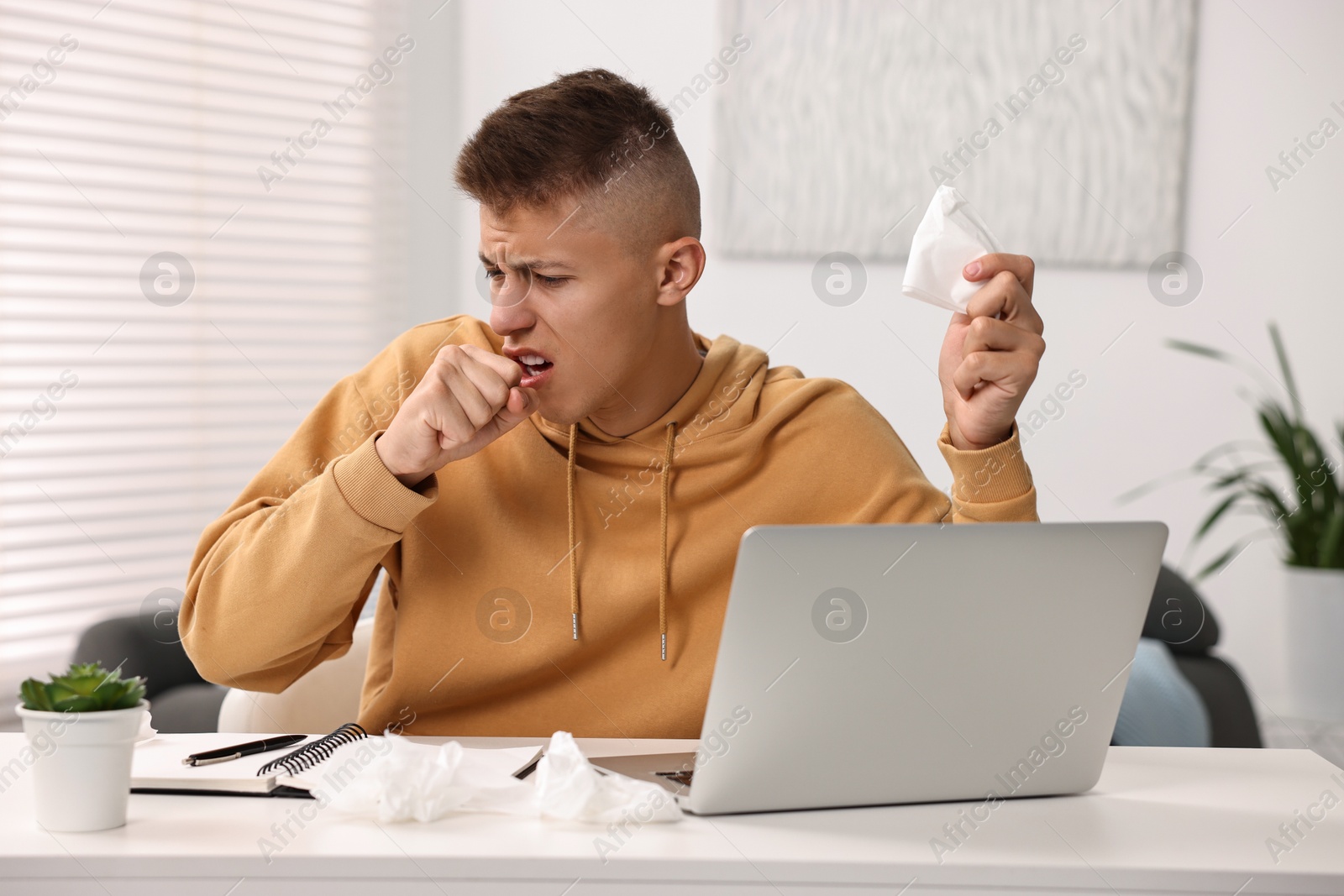 Photo of Cold symptom. Young man coughing at home