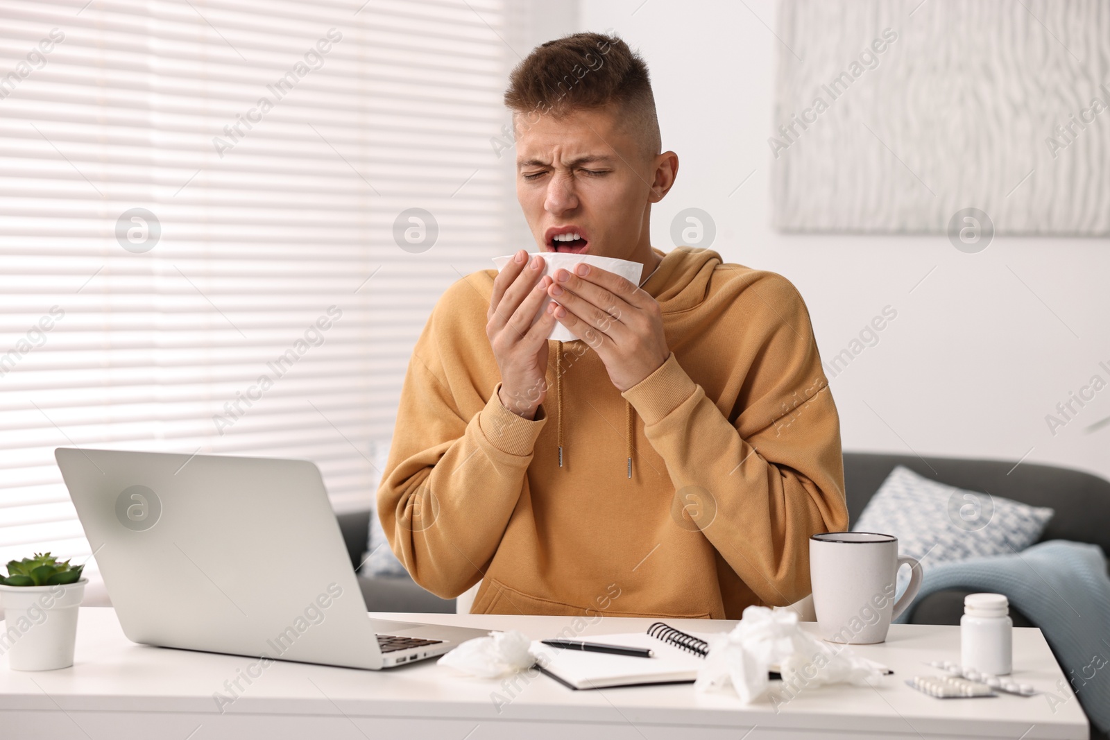 Photo of Cold symptom. Young man with runny nose at home