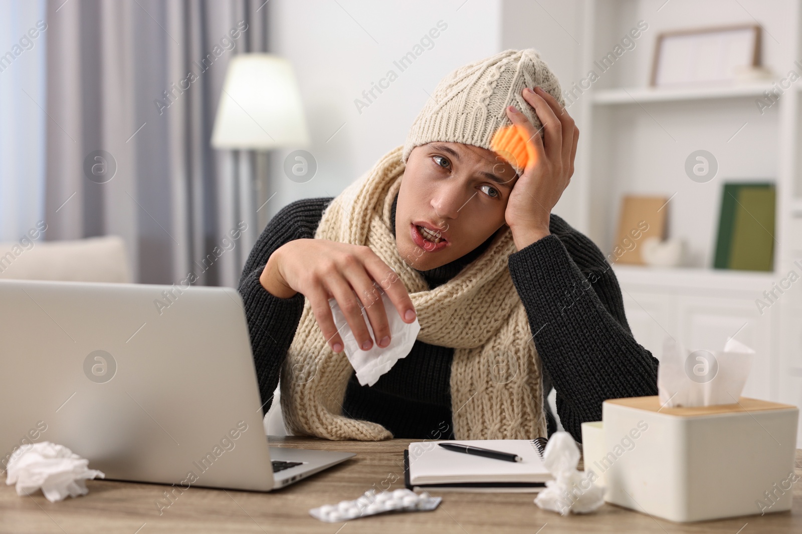 Photo of Cold symptom. Young man suffering from fever at desk indoors