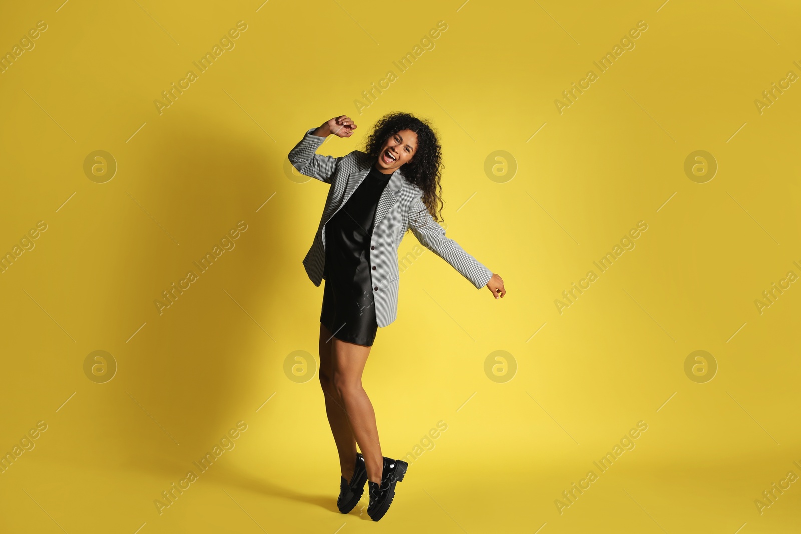 Photo of Beautiful woman in stylish jacket on yellow background