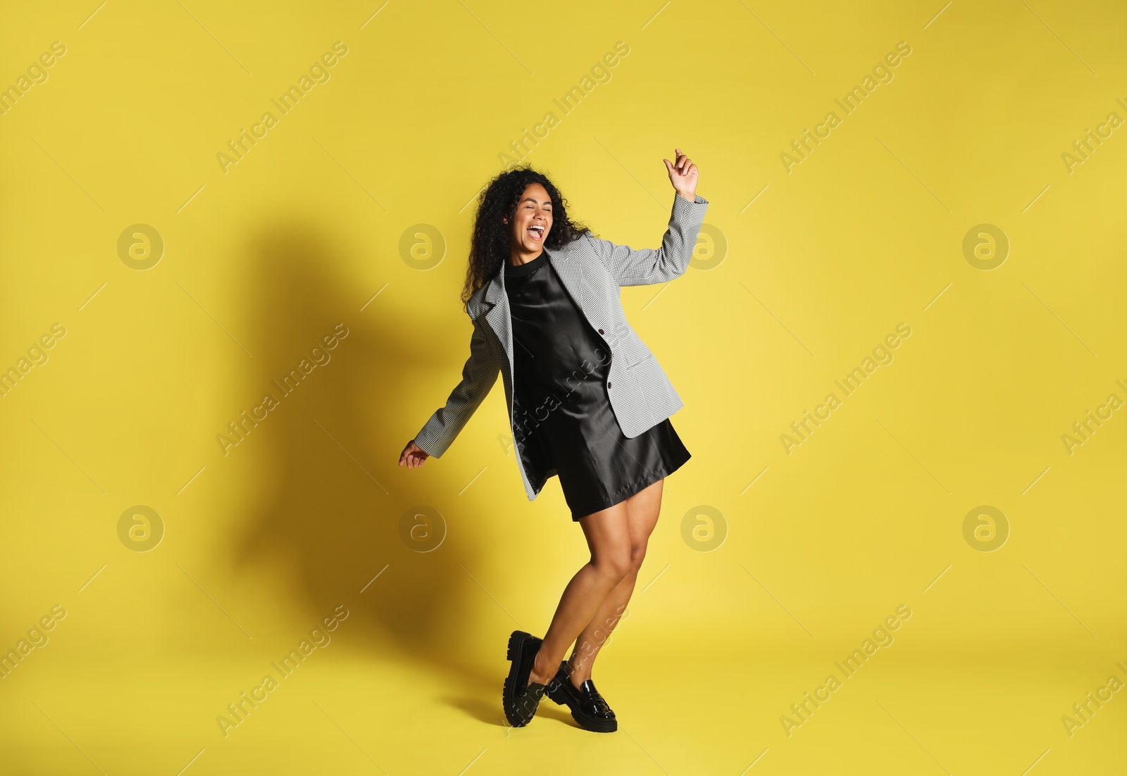 Photo of Beautiful woman in stylish jacket on yellow background