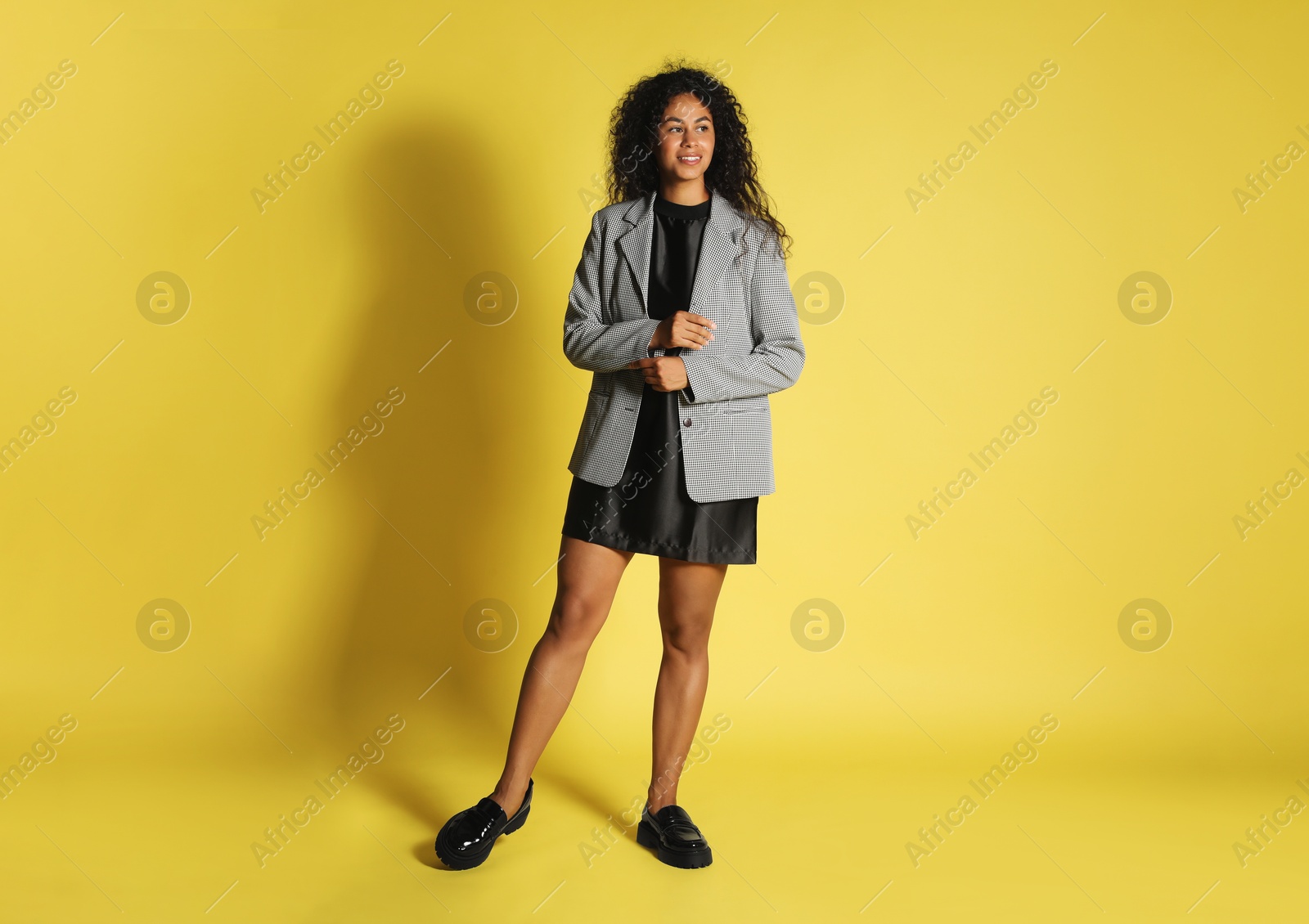 Photo of Beautiful woman in stylish jacket on yellow background