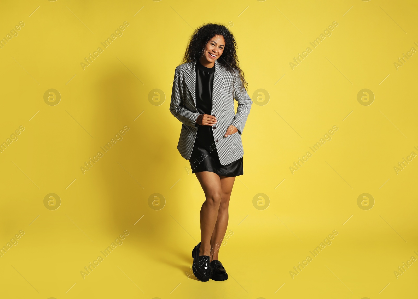 Photo of Beautiful woman in stylish jacket on yellow background