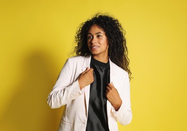 Photo of Beautiful woman in stylish jacket on yellow background