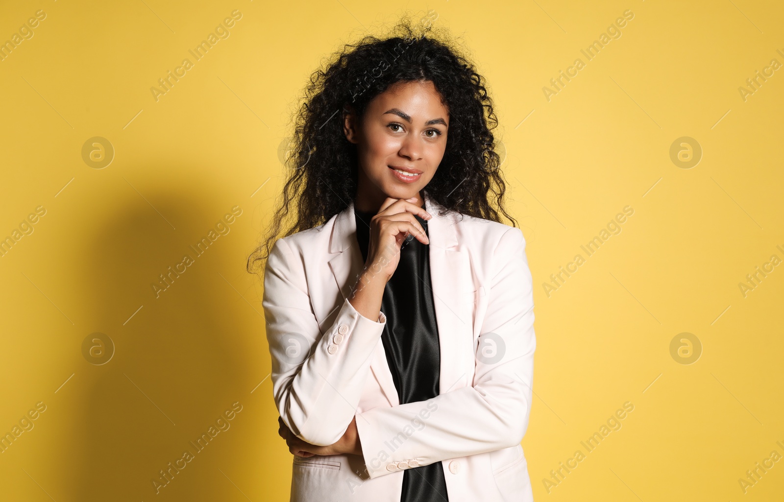 Photo of Beautiful woman in stylish jacket on yellow background