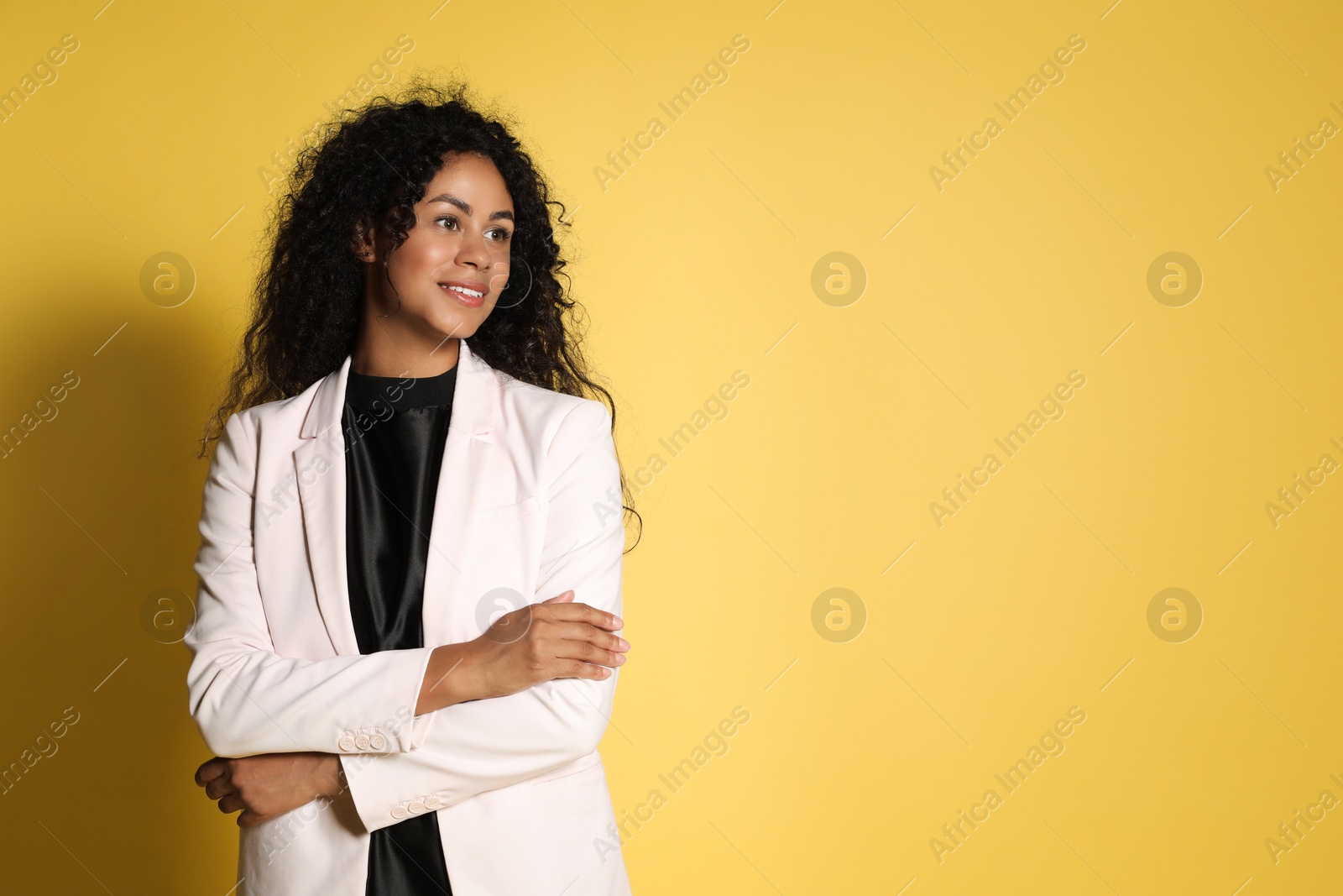 Photo of Beautiful woman in stylish jacket on yellow background, space for text