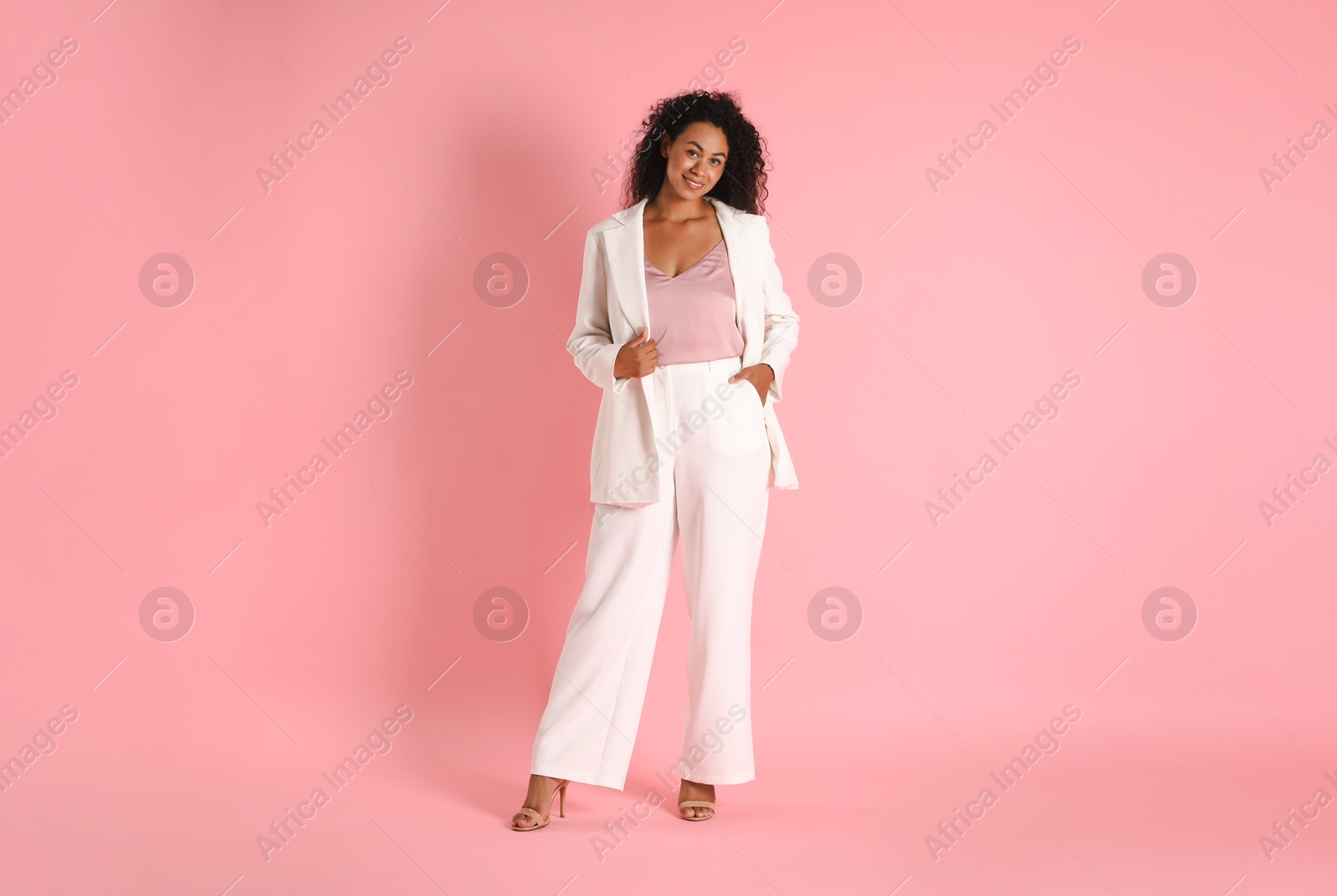 Photo of Beautiful woman in stylish suit on pink background