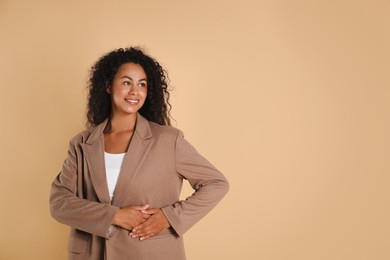 Photo of Beautiful woman in stylish jacket on beige background, space for text