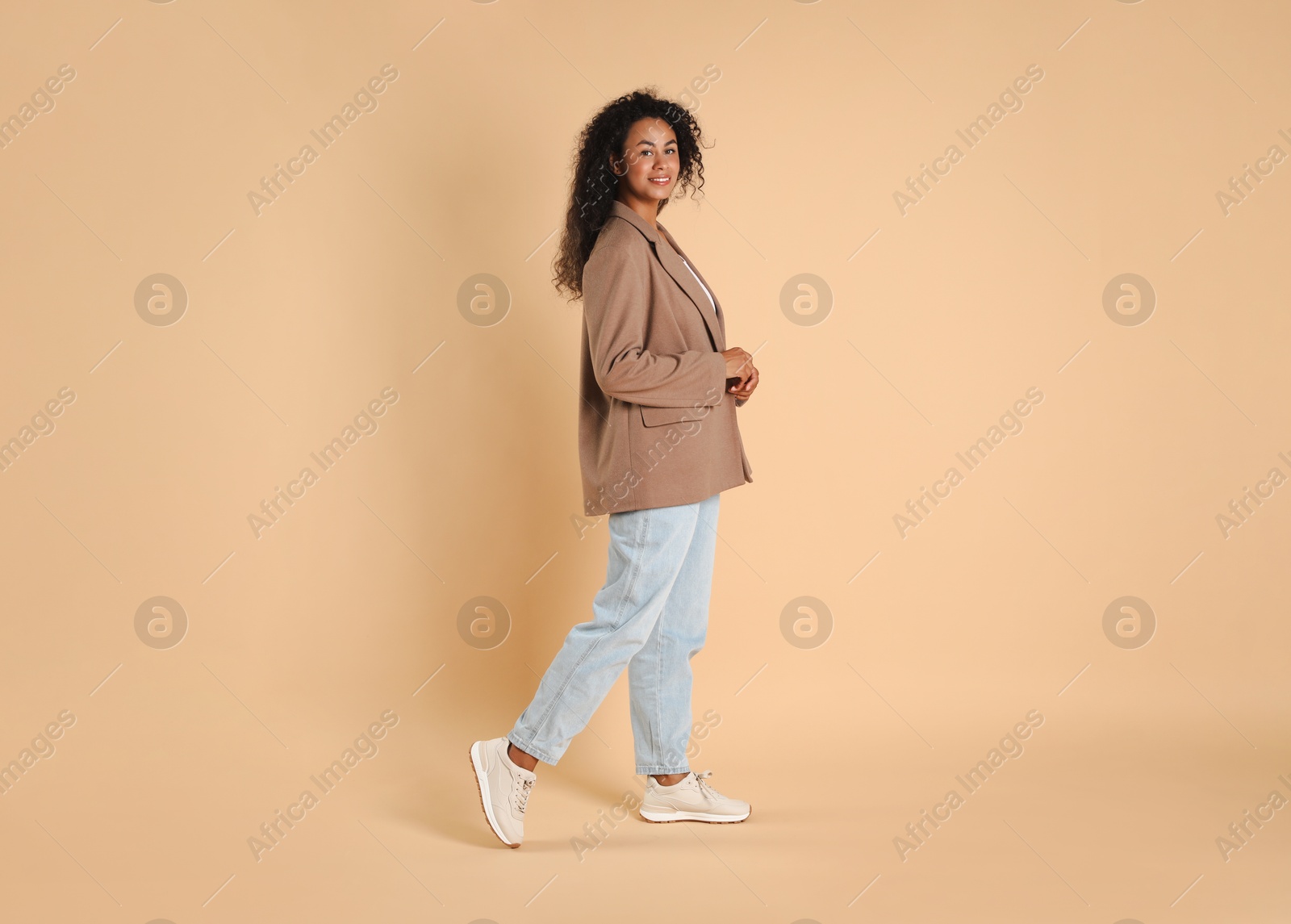 Photo of Beautiful woman in stylish jacket on beige background