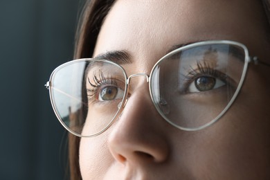 Photo of Closeup view of woman wearing eyeglasses on blurred background