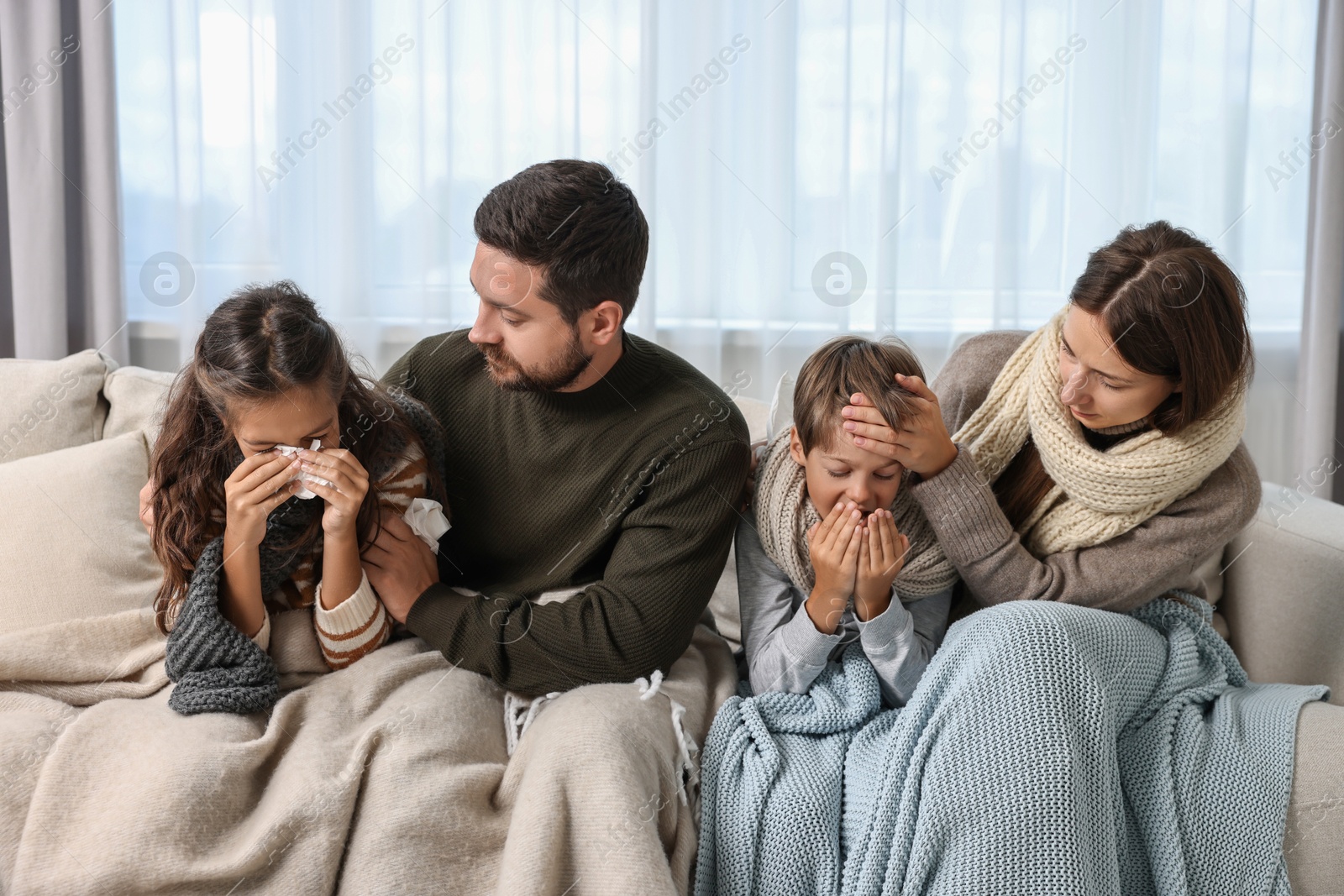 Photo of Cold symptom. Family suffering from fever on sofa at home