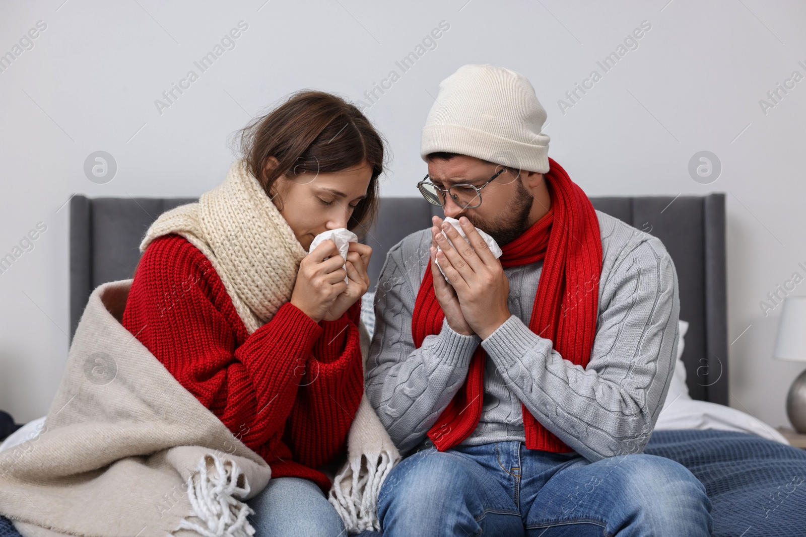 Photo of Cold symptom. Couple suffering from fever on bed at home