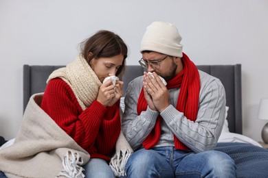 Photo of Cold symptom. Couple suffering from fever on bed at home