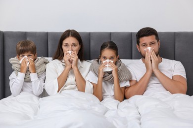 Cold symptom. Family suffering from fever in bed at home