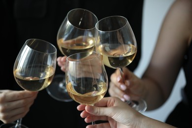 Photo of People clinking glasses of wine indoors, closeup