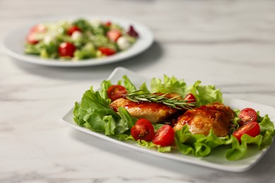 Photo of Delicious dish with chicken on white marble table, closeup