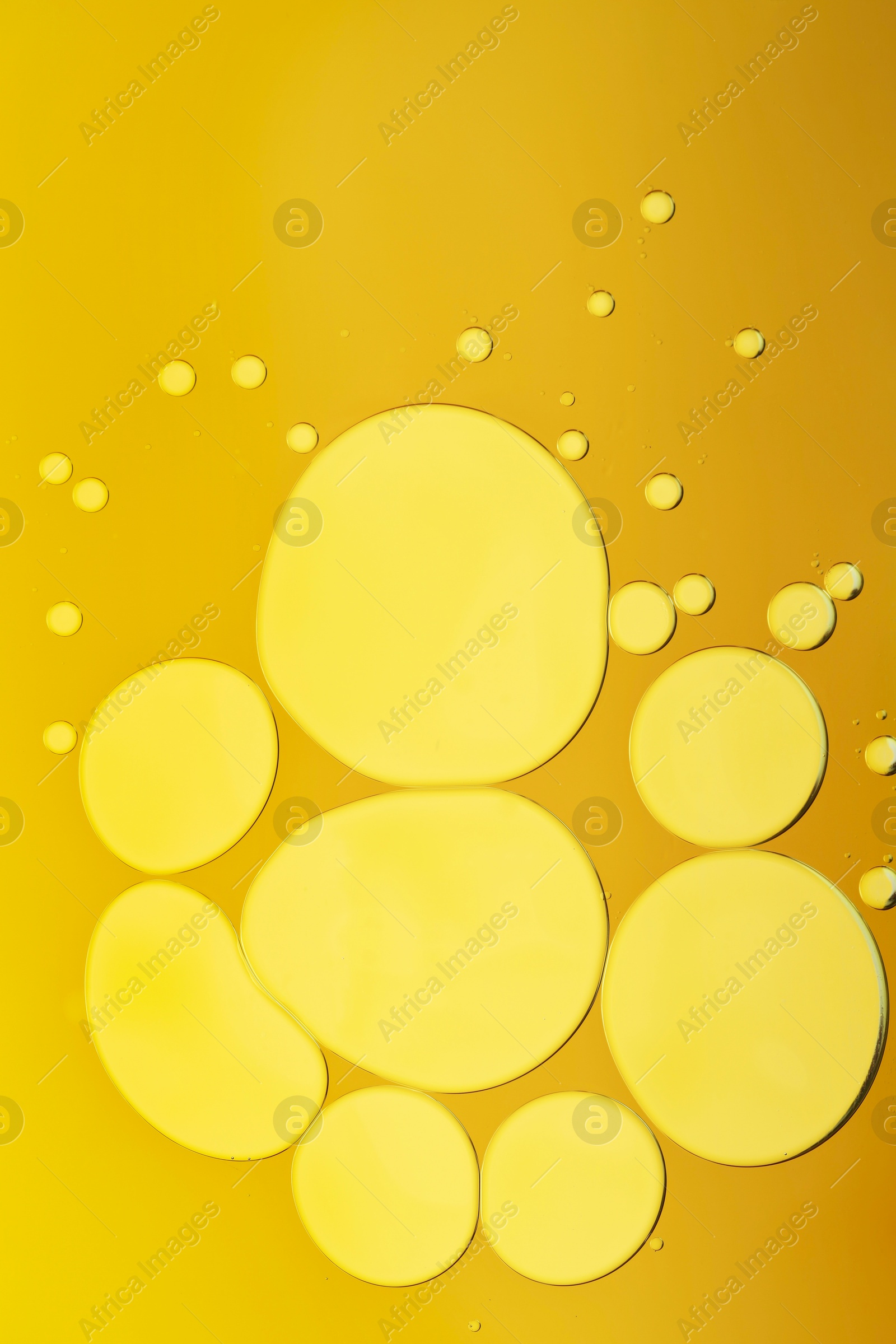 Photo of Sample of cosmetic oil on dark yellow background, macro view