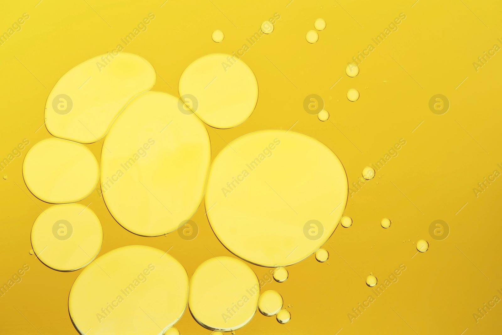 Photo of Sample of cosmetic oil on dark yellow background, macro view