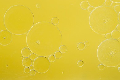 Photo of Sample of cosmetic oil on yellow background, macro view