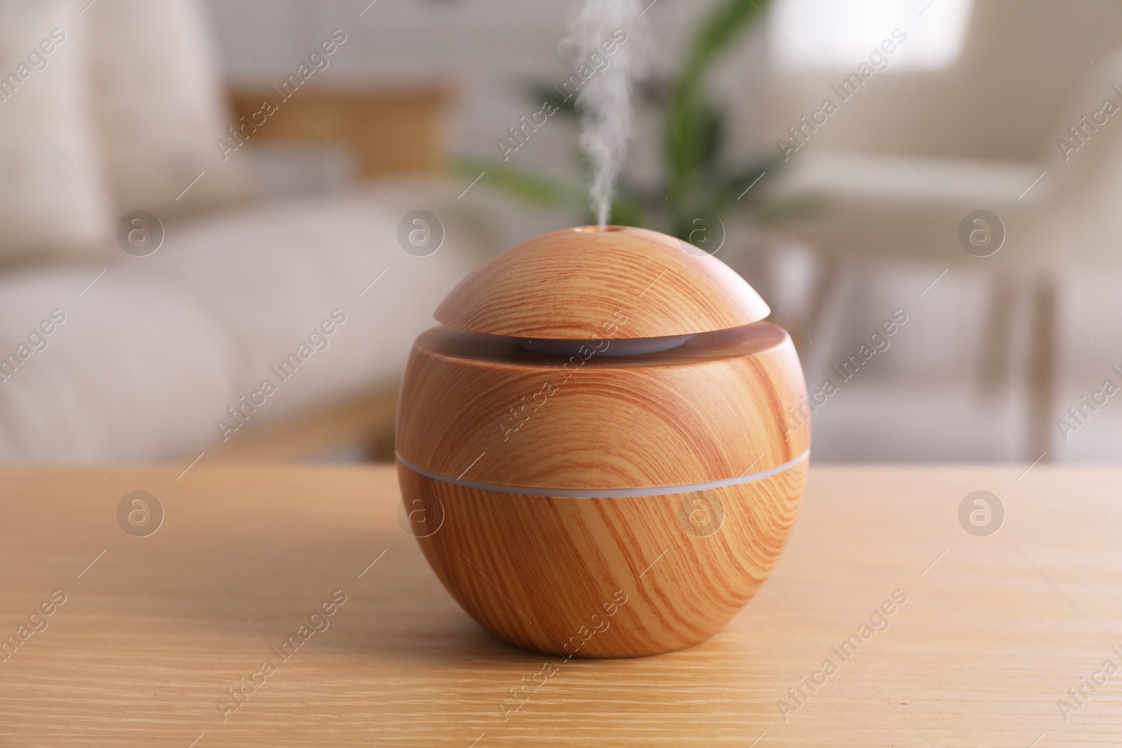 Photo of Essential oil diffuser on wooden table at home