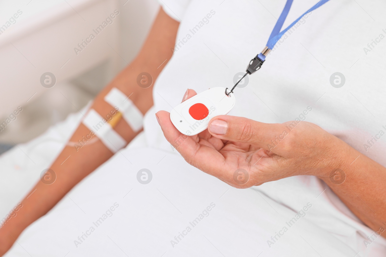 Photo of Senior woman with emergency call button on bed in hospital, closeup