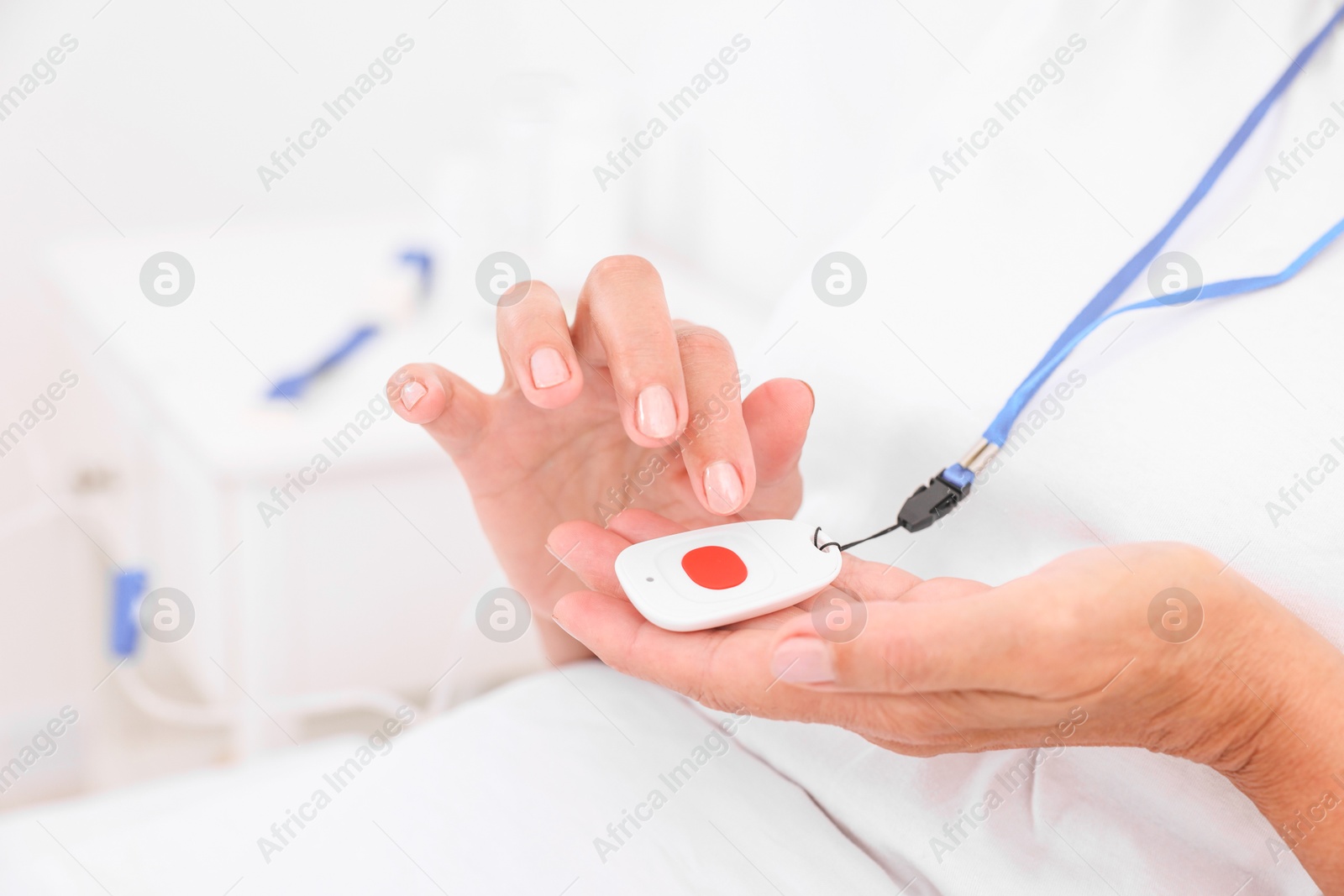 Photo of Senior woman with emergency call button on bed in hospital, closeup